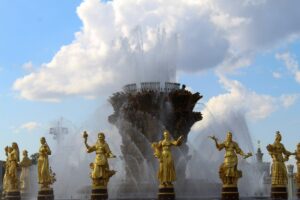 Stunning fountain with golden statues under a blue sky at VDNKh, showcasing artistic craftsmanship.
